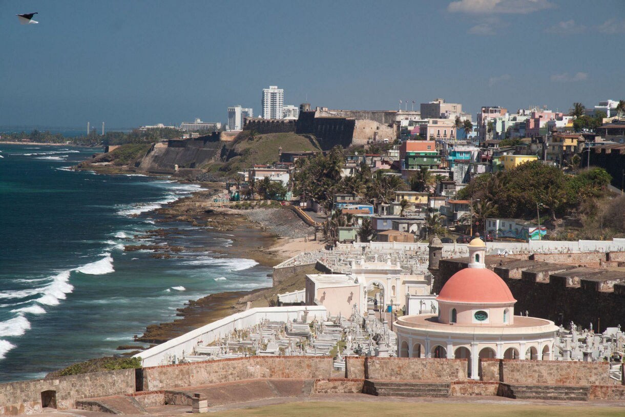 A panoramic view of Old San Juan, Puerto Rico, showcasing vibrant colonial buildings and the historic citadel overlooking the sea.