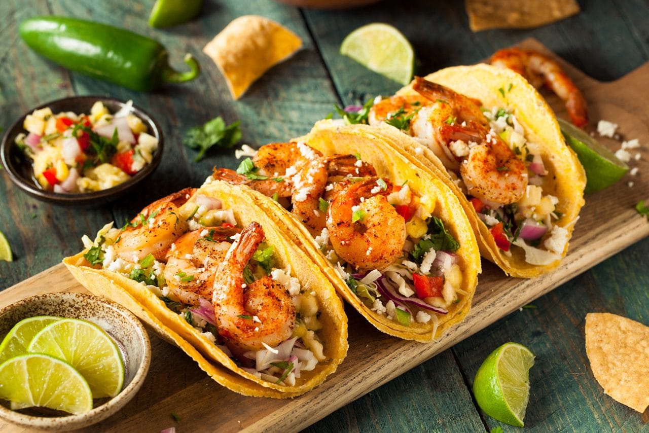 Three shrimp tacos with fresh ingredientes.