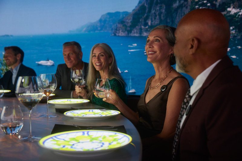 Diners seated at a table with uniquely illuminated plates creating an ambient glow. 