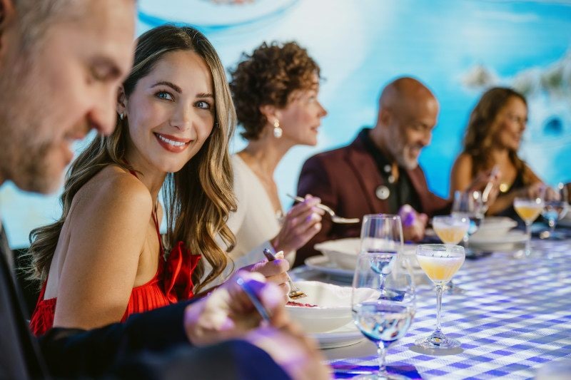 Guests engaged in conversation around a formally set dining table.