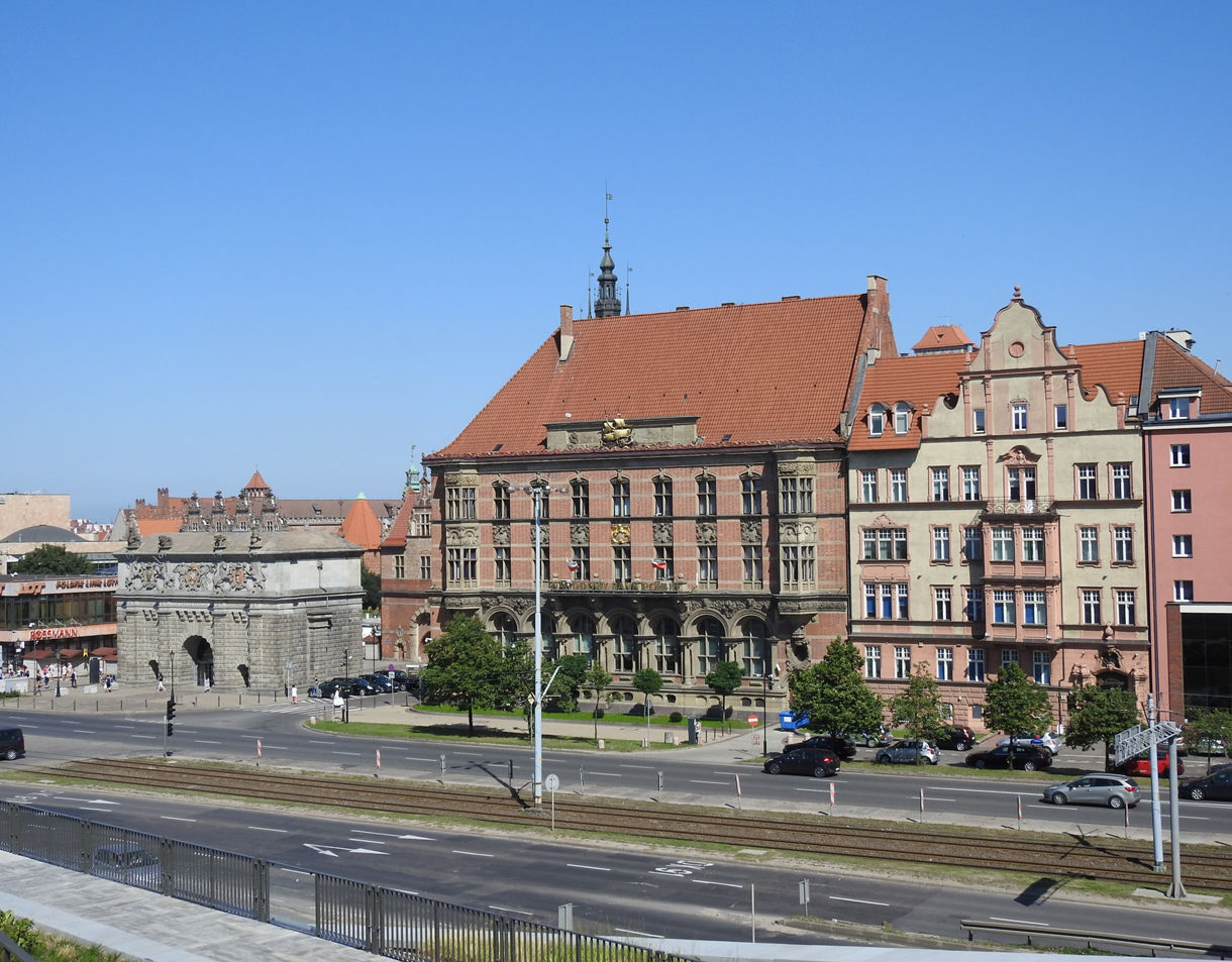 The Amber Museum in Gdańsk, housed in a historic building with ornate stonework, red-tiled roof and nearby 17th-century city gate.