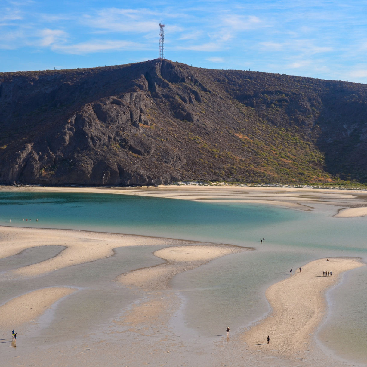 Aerial view of Balandra Beach in La Paz, showing winding sandbars, shallow turquoise water and surrounding rocky hills.
