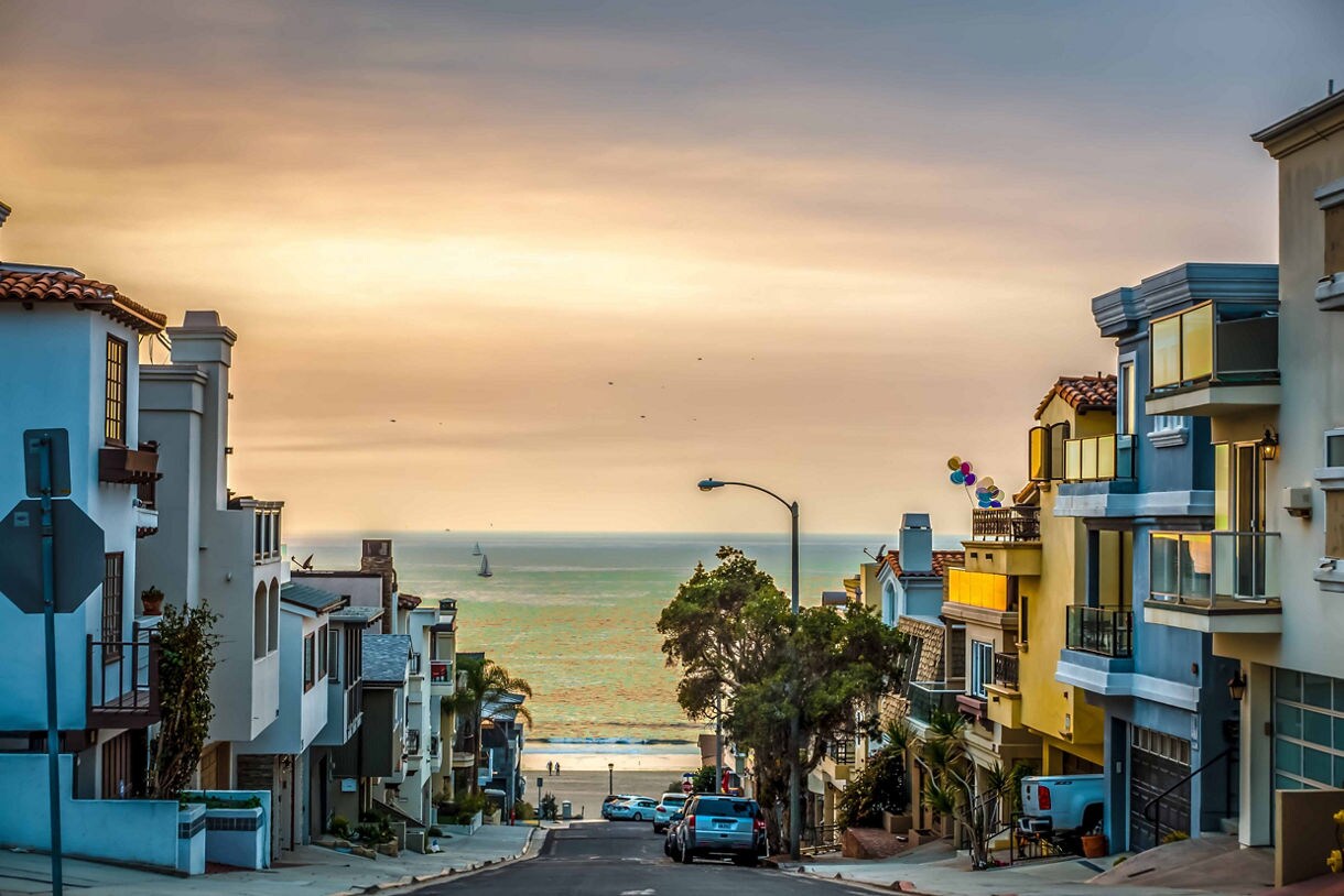 A scenic street leading to Bolsa Chica State Beach at sunset, lined with colorful beachfront homes.