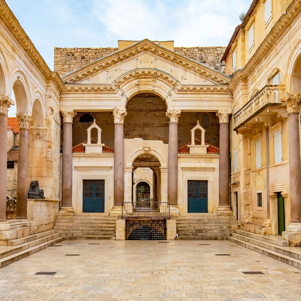 Open courtyard of Diocletian’s Palace in Split with tall columns, carved arches and weathered stone architecture under soft daylight.