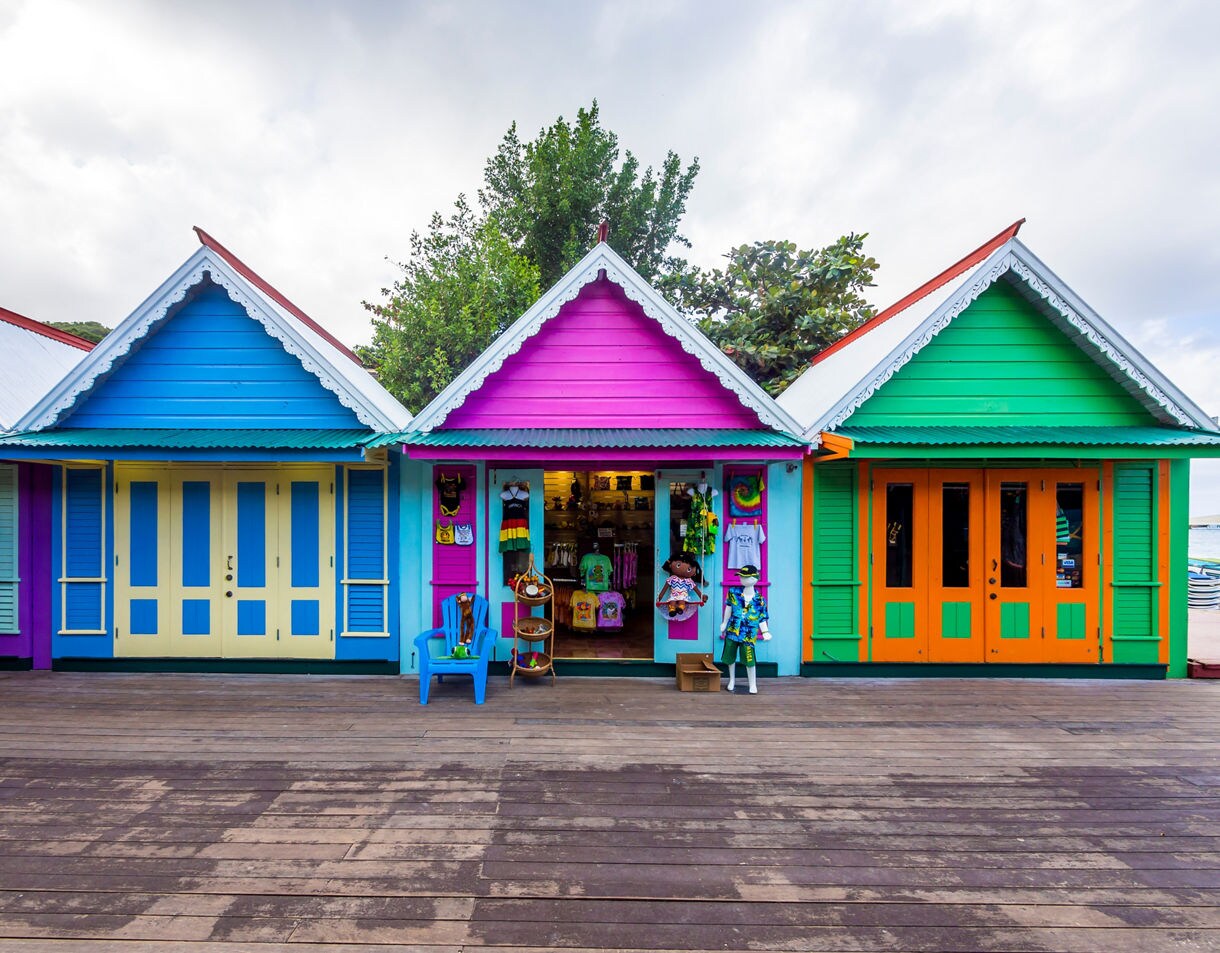 Vibrant row of brightly painted wooden shops in blue, pink and green at Fisherman’s Point, Ocho Rios, Jamaica.
