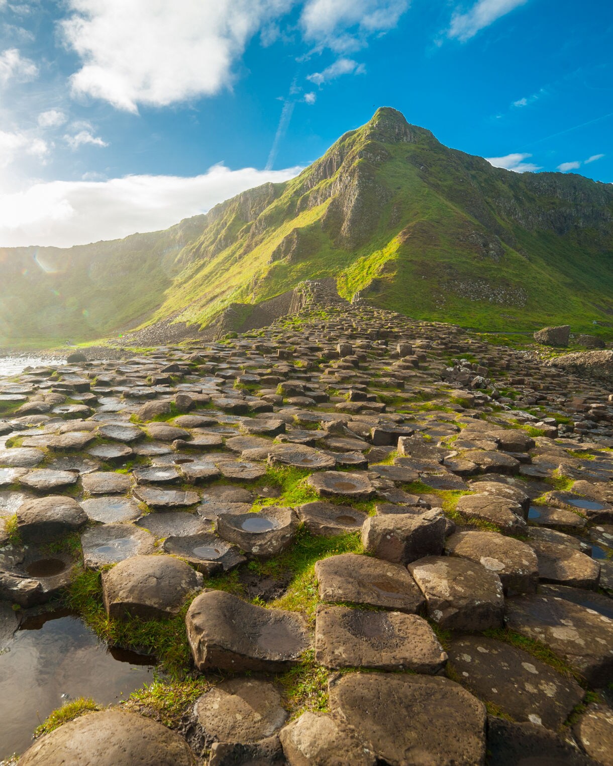 The Giant's Causeway at dawn on a sunny day with the famous basalt columns, the result of an ancient volcanic eruption.