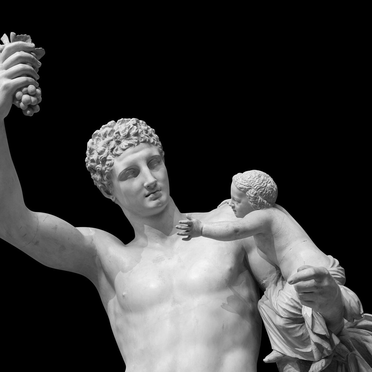 Marble statue of Hermes holding baby Dionysus, with Hermes raising a cluster of grapes, set against a black background.