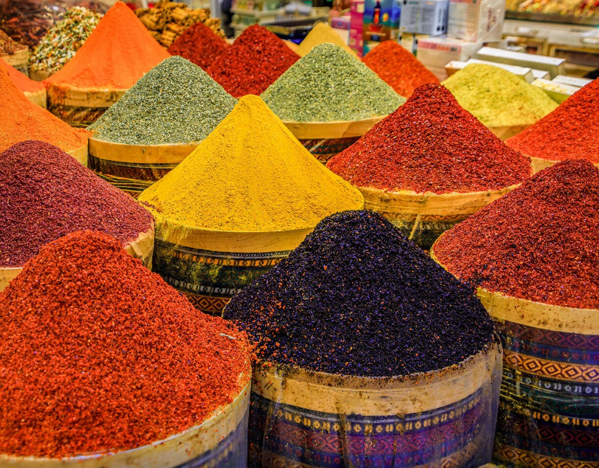 Colorful mounds of spices in red, yellow, green and black stacked in baskets at Istanbul’s famous Spice Market.