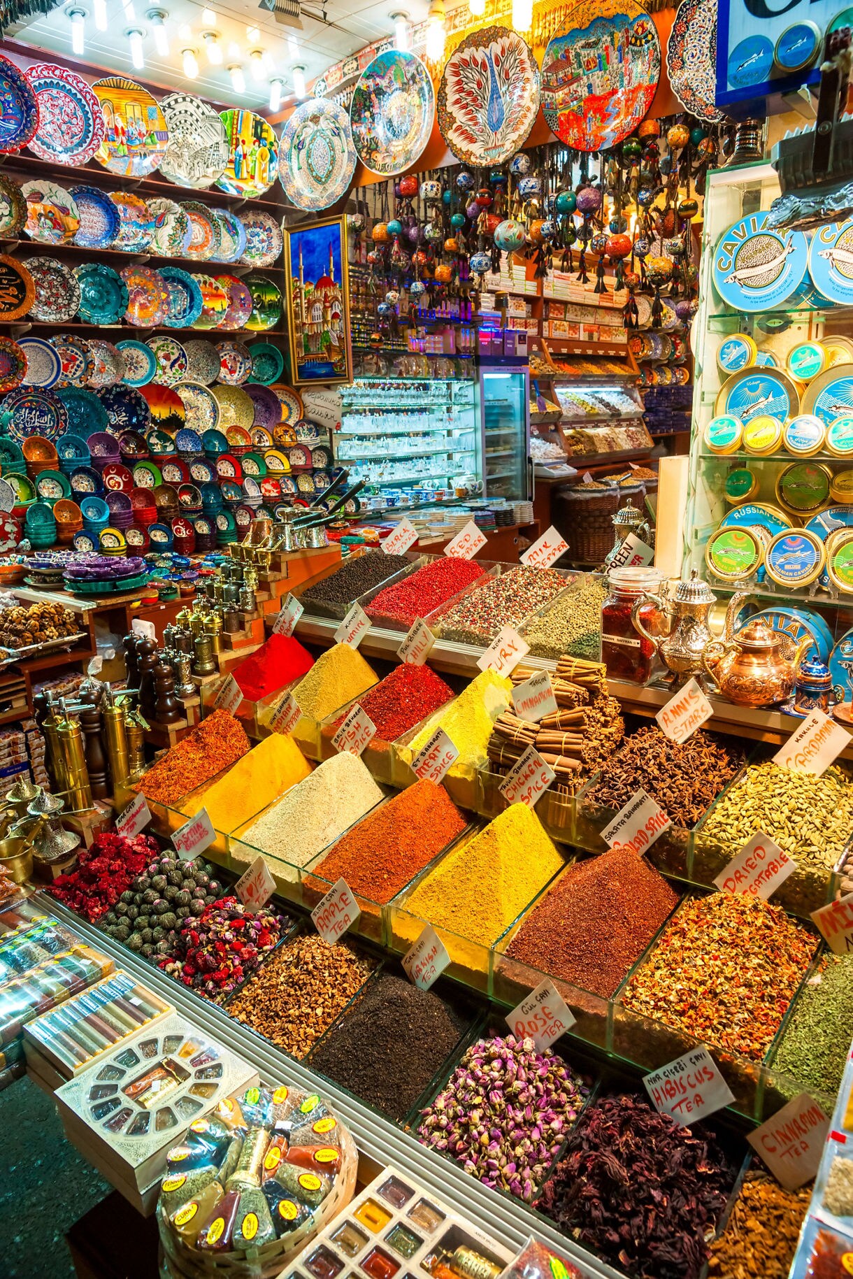 Colorful spice piles, dried herbs and ornate ceramic plates on display inside Istanbul’s bustling Grand Bazaar.