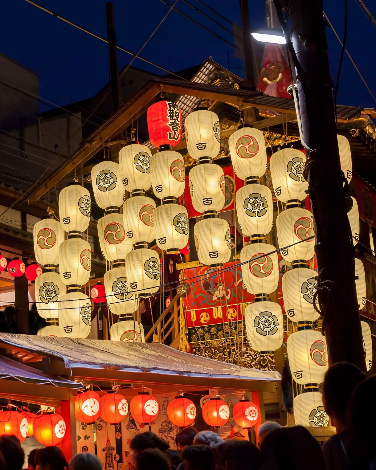 Night view of Yamahoko float with lanterns and people listening to music in Gion Festival in Kyoto, Japan