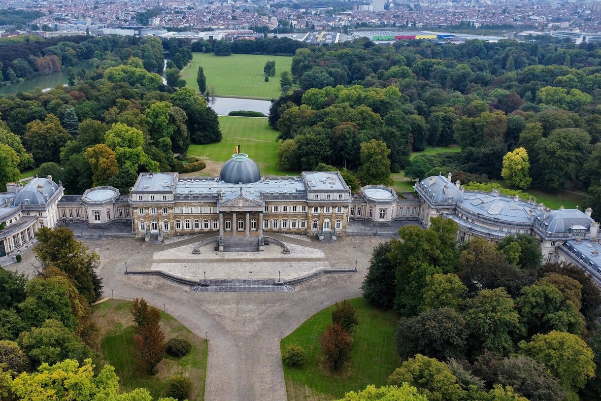 Aerial view of the Royal Castle of Laeken in Brussels, Belgium, with its domed central building, symmetrical wings and vast landscaped gardens.