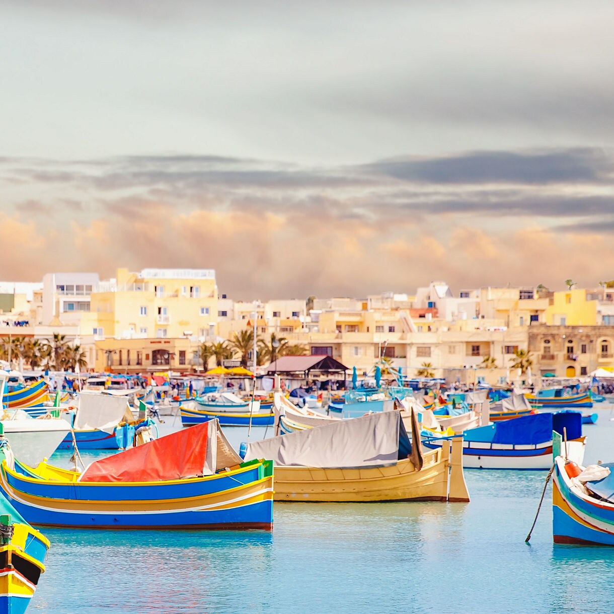 Colorful traditional fishing boats in the harbor of Marsaxlokk village, Malta.