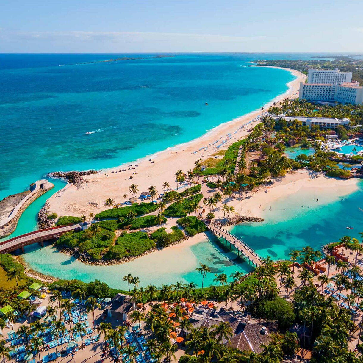Aerial view of Paradise Island in Nassau showing beachfront resorts, turquoise waters and palm-lined pools.