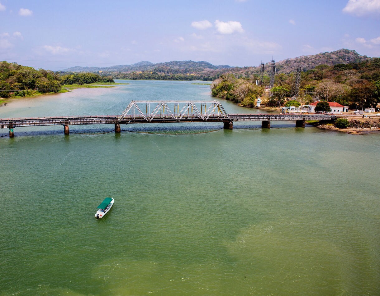 Green tropical islands surrounded by blue waters of Gatun Lake in Panama under a bright, partly cloudy sky.