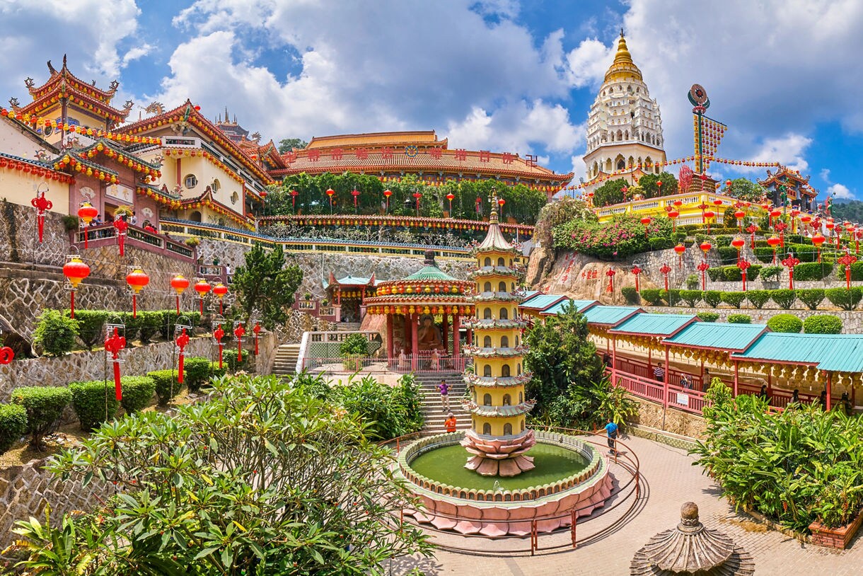 Kek Lok Si Temple in Penang, Malaysia, featuring a towering pagoda, colorful lanterns and ornate architecture on a hillside.