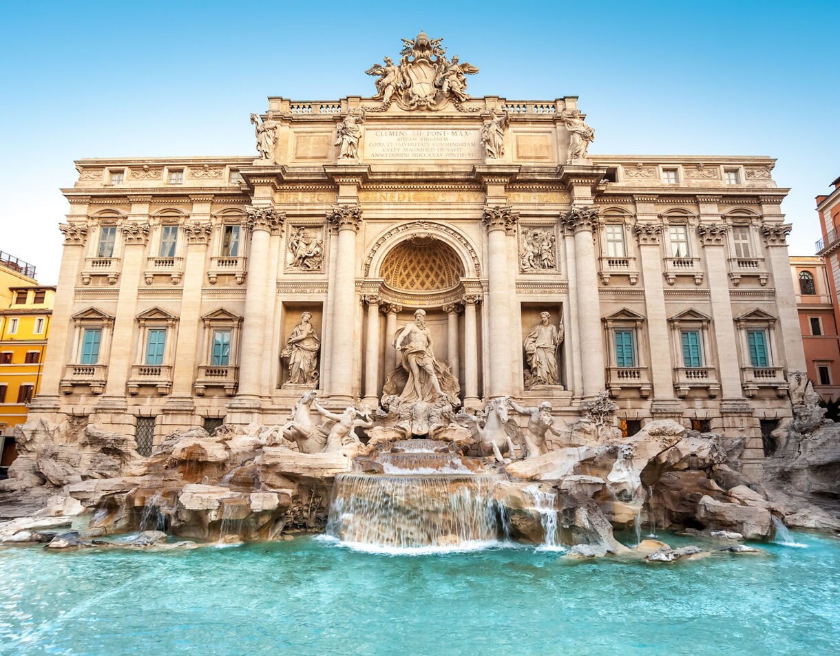 The Trevi Fountain in Rome with cascading water, ornate statues, and a grand Baroque façade.