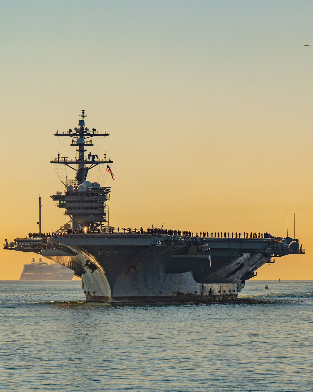 Witness the power of San Diego’s naval pride as an aircraft carrier sails at sunset with a helicopter overhead.