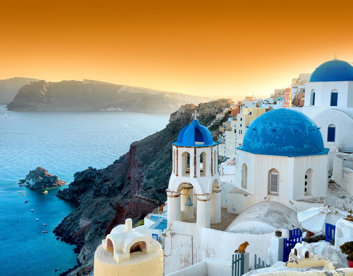 Santorini’s Oia village with bright blue-domed churches and whitewashed buildings