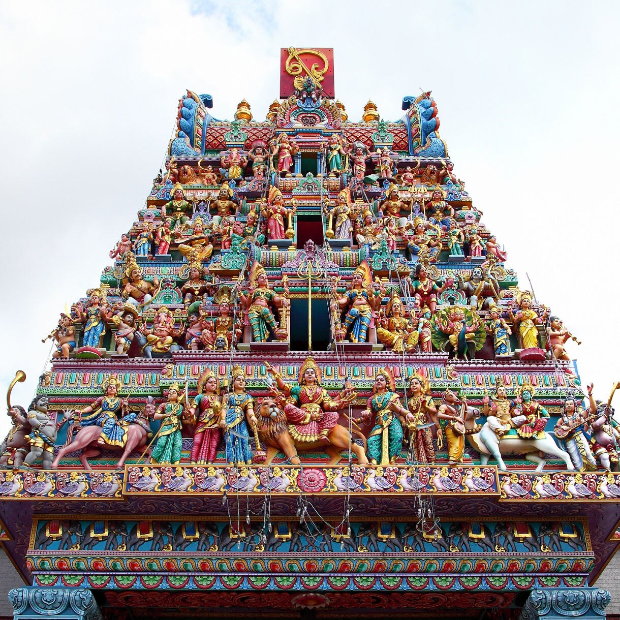 Ornate, colorful tower of Sri Veeramakaliamman Temple in Singapore’s Little India, decorated with intricate Hindu deities and figures.