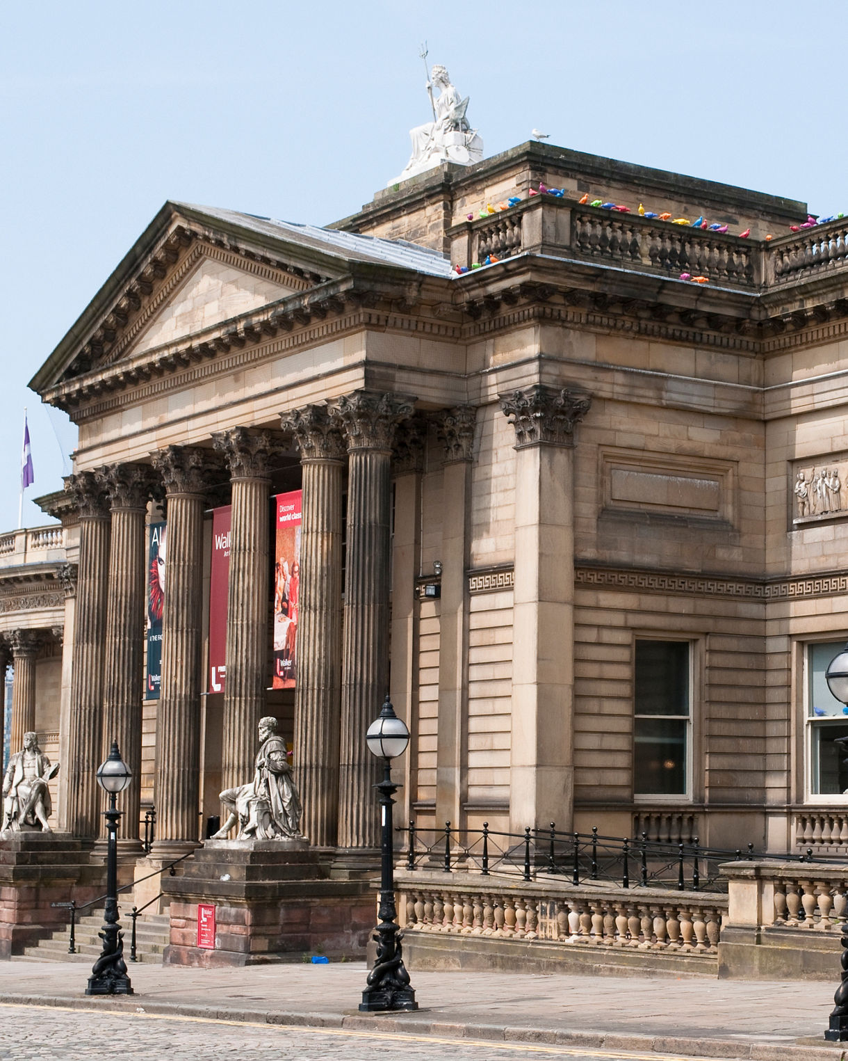 Neoclassical facade of the Walker Art Gallery in Liverpool, featuring tall columns, stone statues, and detailed friezes on the exterior walls.