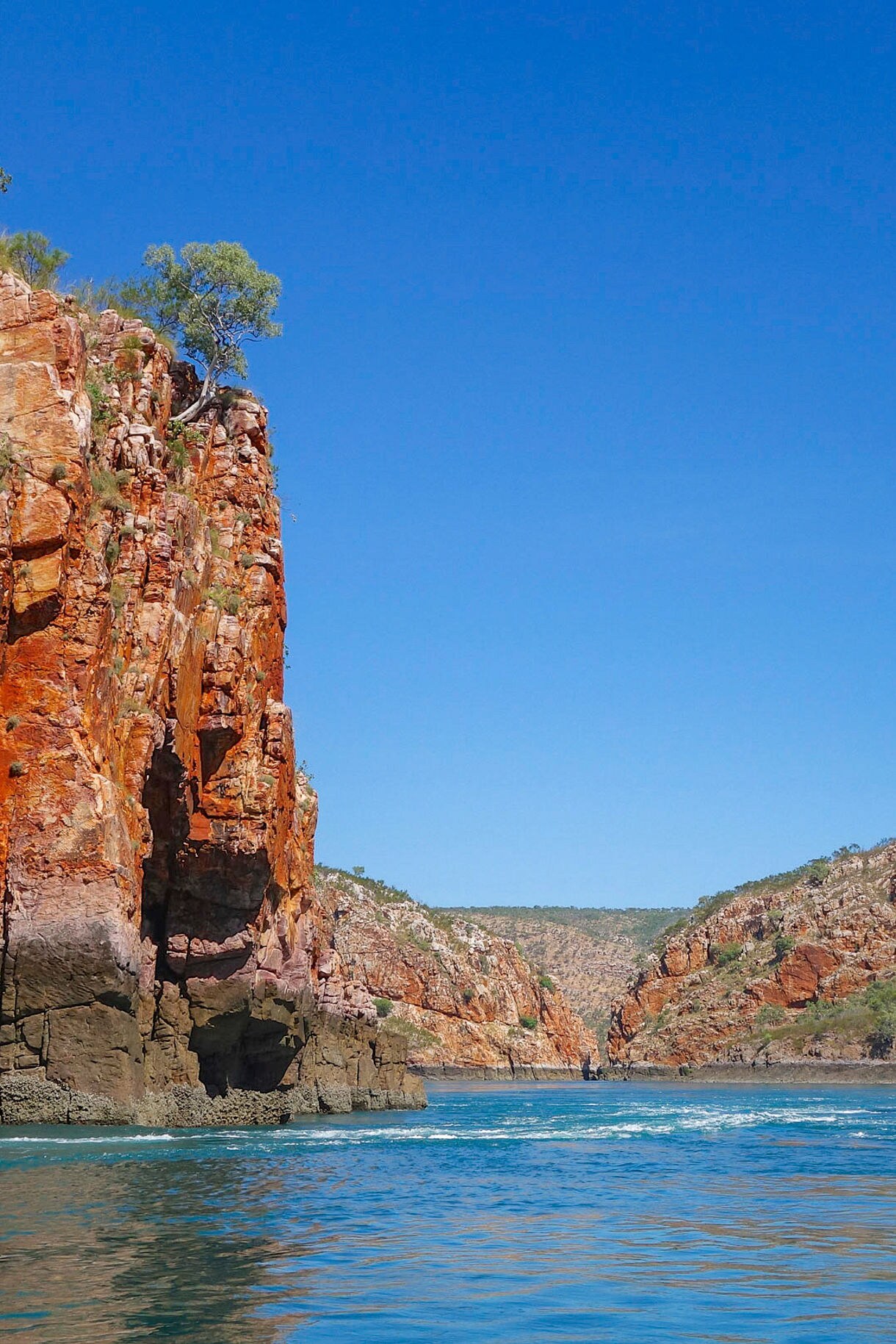 Aerial view of Yampi Sound showing vivid turquoise water, rocky islets, and white swirling tidal currents moving between the rocks.