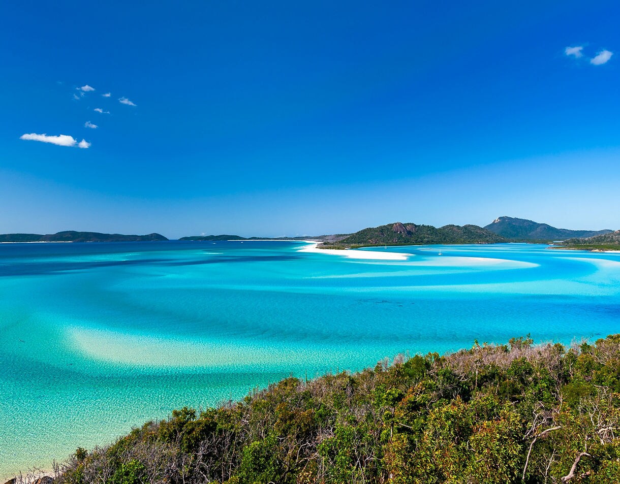 Hill Inlet at Whitsunday Island - swirling white sands, sail boats and blue green water make spectacular patterns on a beautiful clear blue sky day.