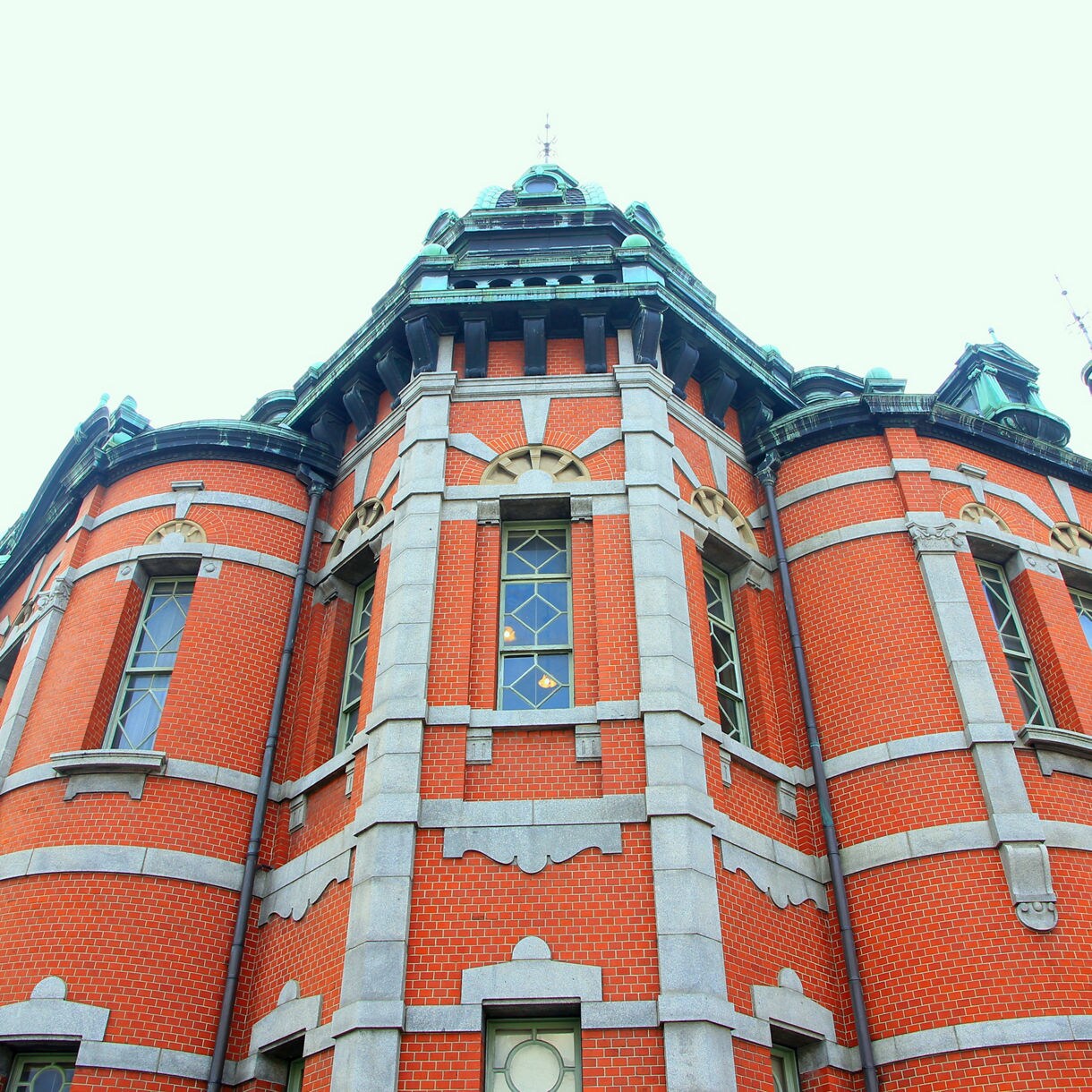Close-up of a red brick Western-style building with arched windows and stone trim, part of Akita's Folk Museum.