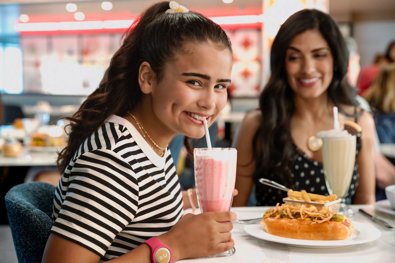 Mother and daughter having milkshakes