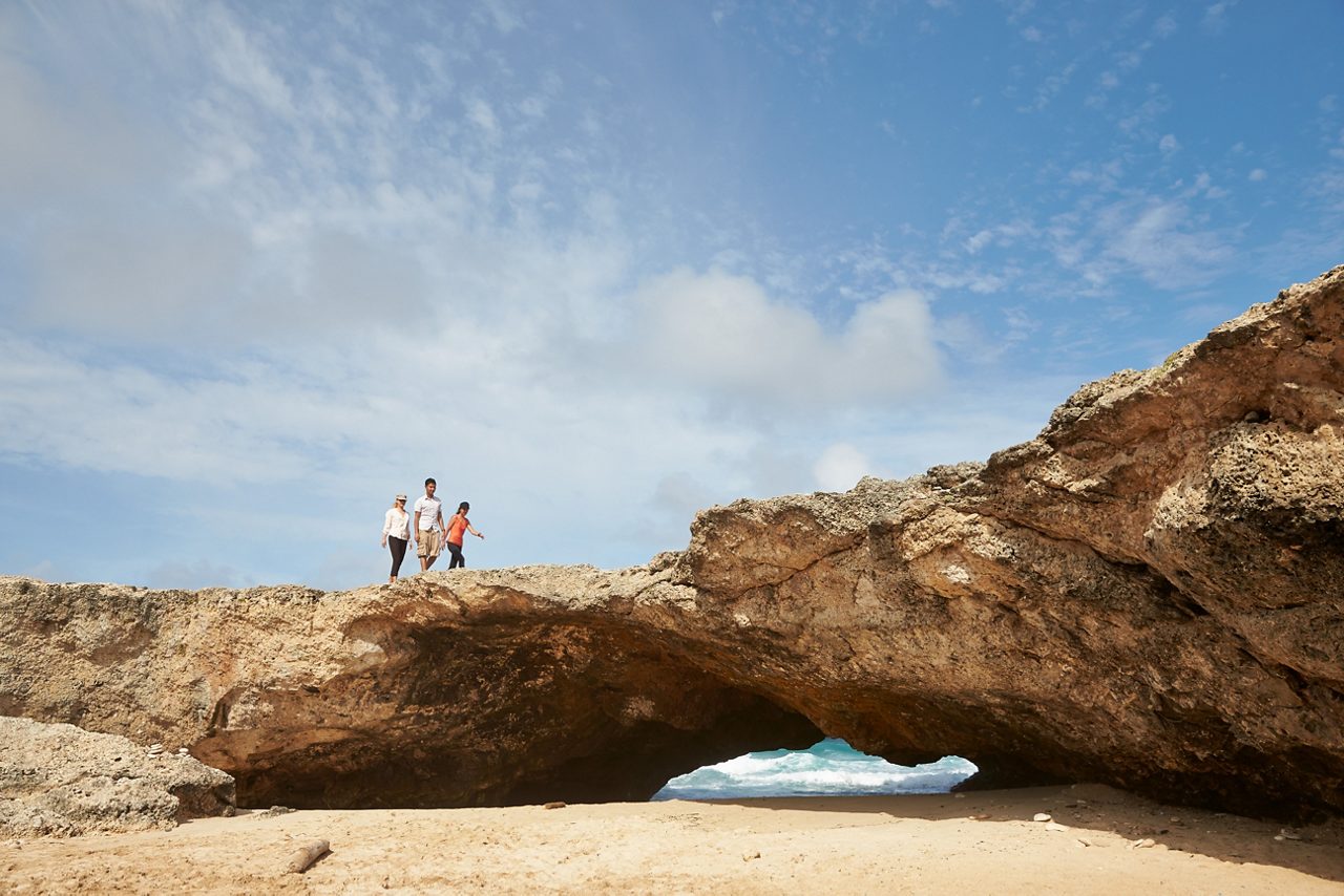 Family on top of a rock - caribbean beach