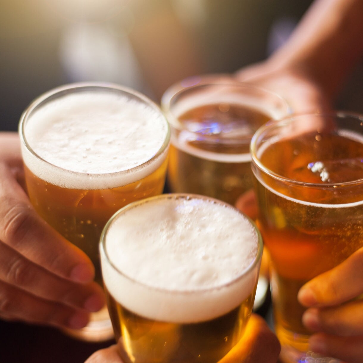 A plated dish of creamy pasta topped with shrimp and garnished with herbs, served on a white plate atop a patterned tablecloth with a glass of wine nearby.