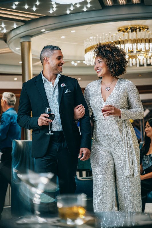 Two people sharing an intimate moment at a lounge table with drinks.