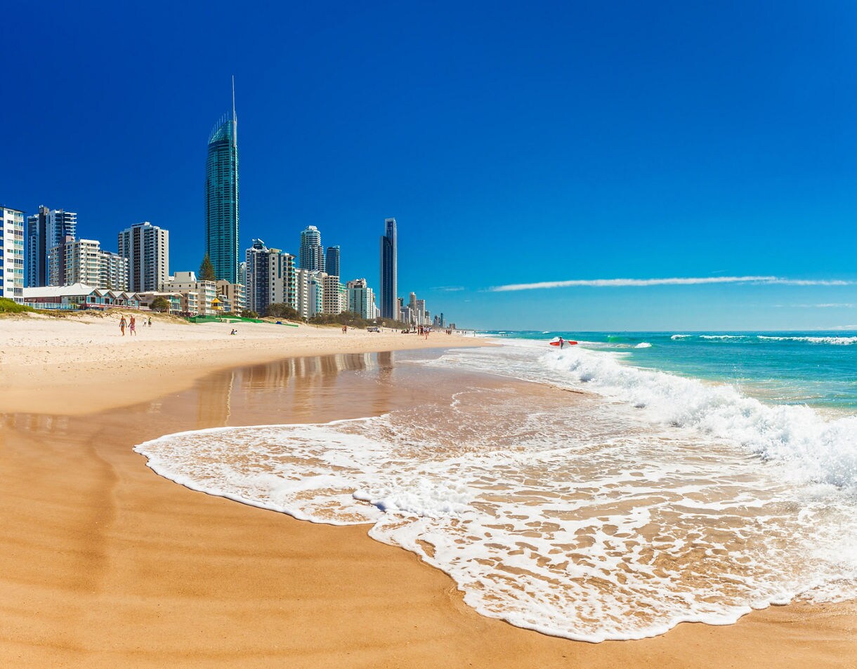 Wide view of Gold Coast shoreline with turquoise water and the Surfers Paradise skyline.