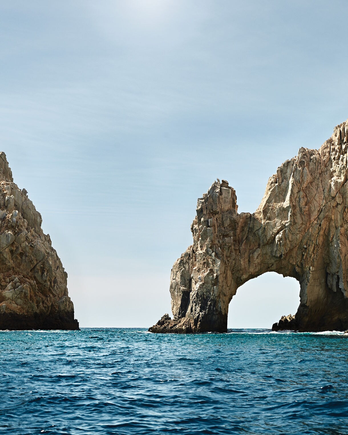 View of the iconic Arch of Cabo San Lucas surrounded by clear blue waters. 