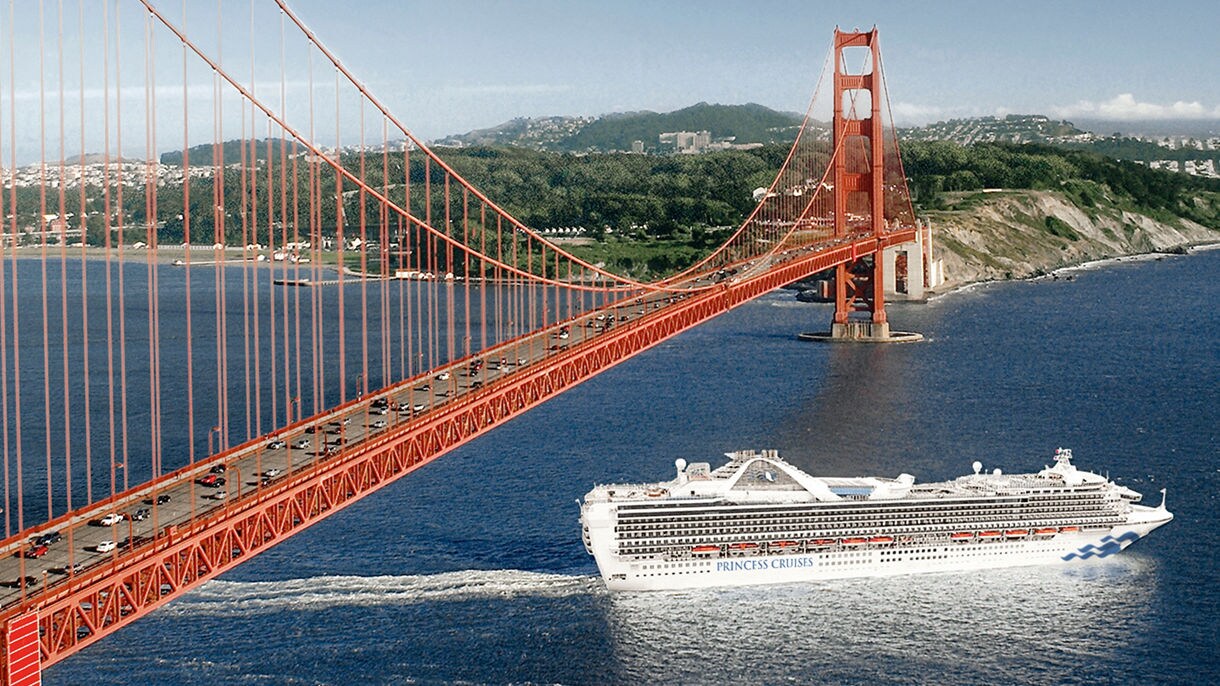 A golden sunset view of downtown Los Angeles with tall palm trees and residential neighborhoods in the foreground, bathed in warm light and hazy atmosphere.