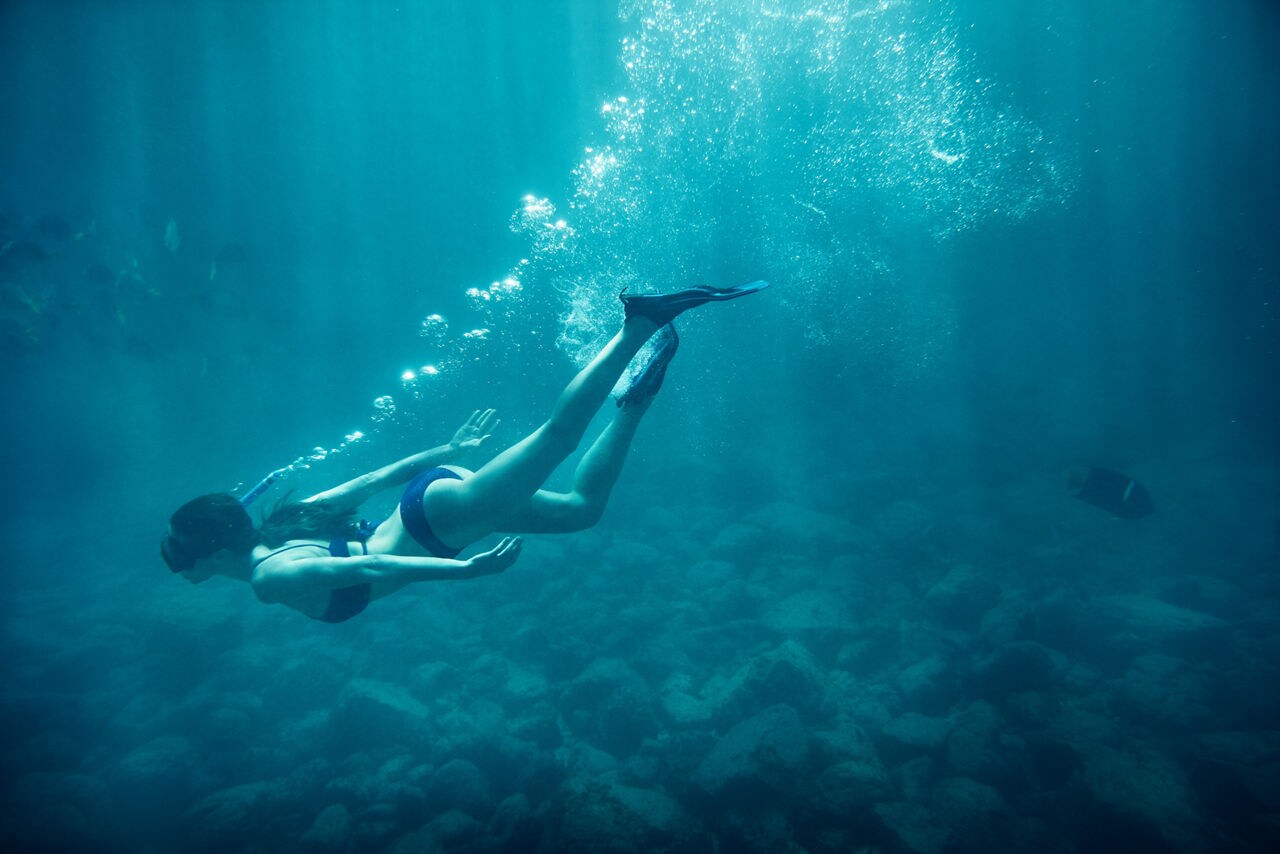 caribbean woman snorkelling underwater blue bikini