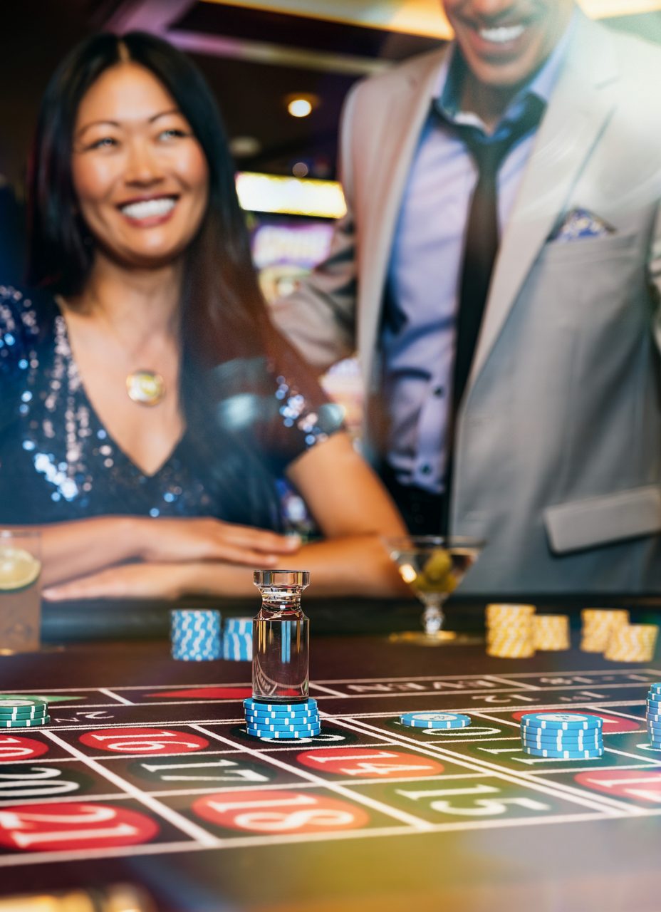 A smiling couple enjoys a game of roulette, sharing a moment of excitement at the Princess Cruise casino.
