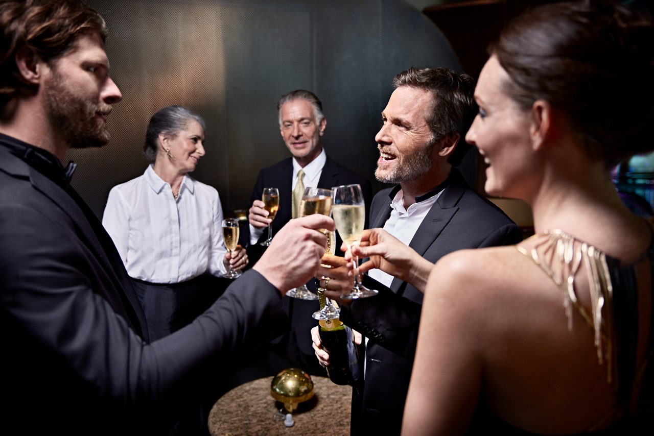 couples dressed in elegant clothes enjoying a cocktail party