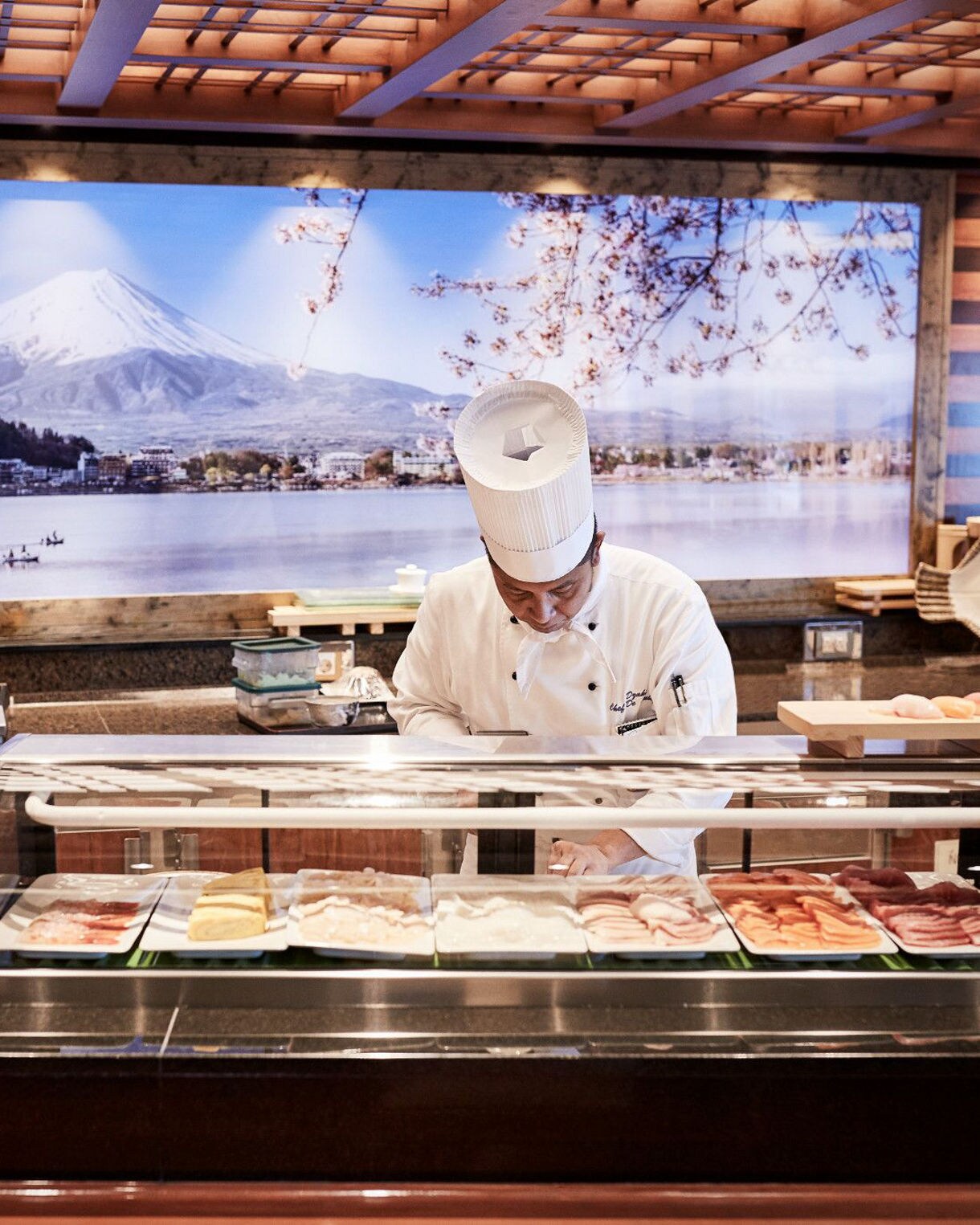 Modern sushi bar with elegant dining setup and Mt. Fuji decor.
