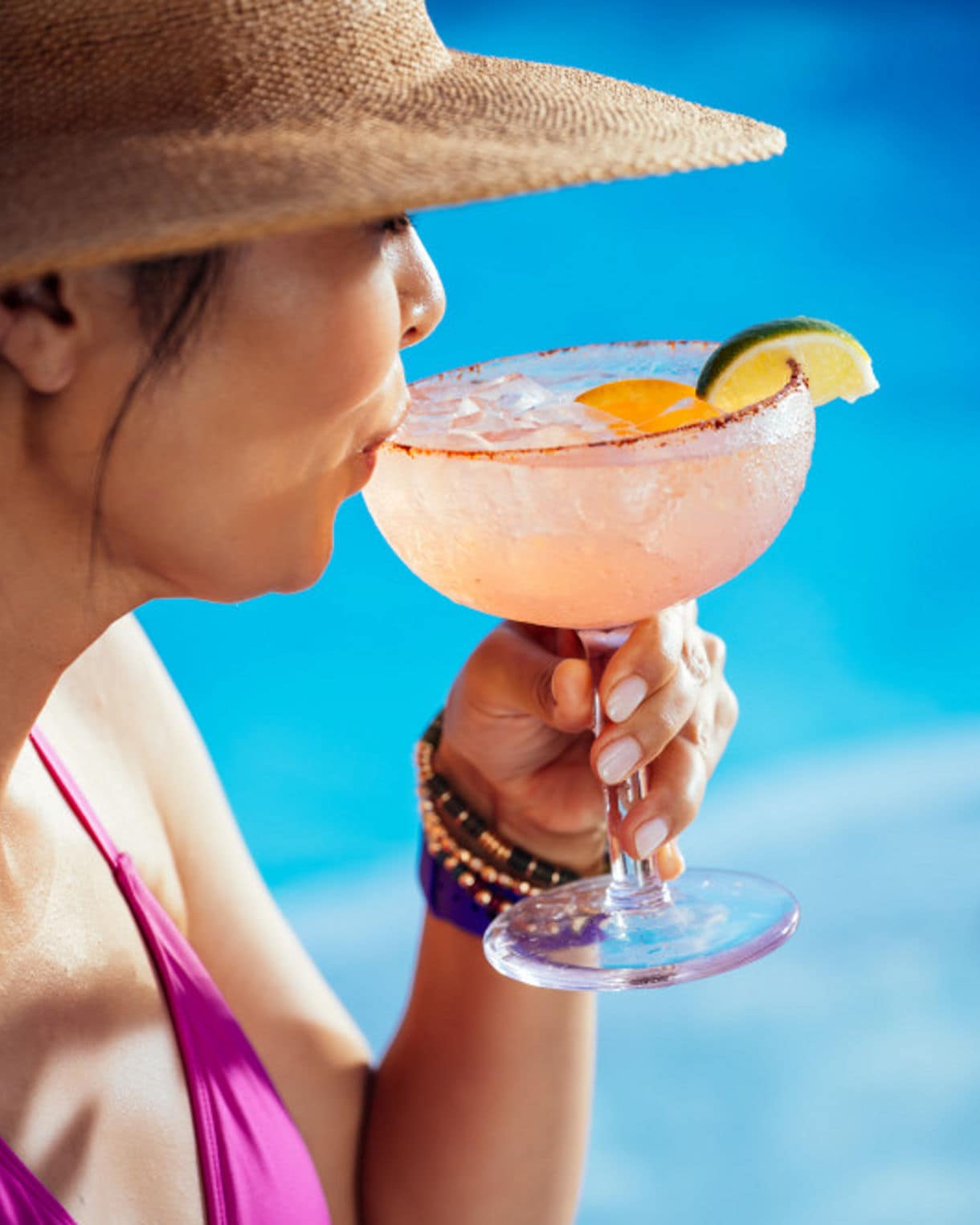 Selection of colorful cocktails with ocean backdrop.