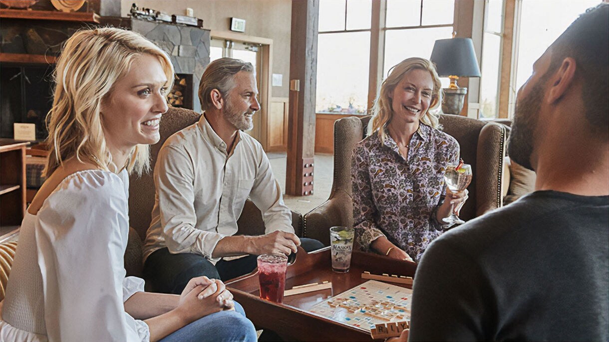 Guests play board games in lobby of Copper River Princess Wilderness Lodge