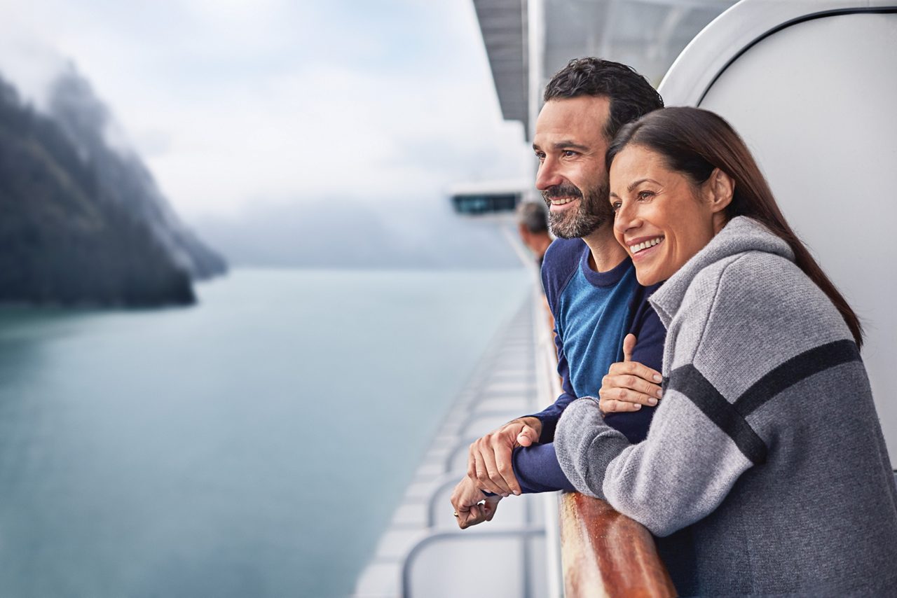 Couple at ship balcony in Alaska.