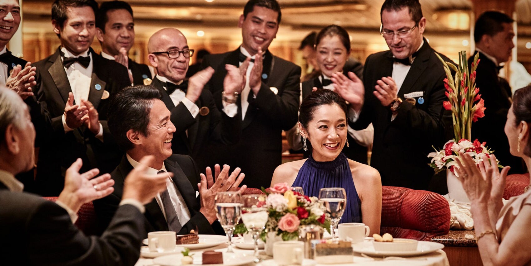 People around a table clapping and celebrating