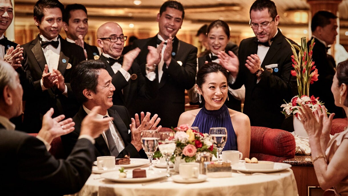 people around a table clapping and celebrating