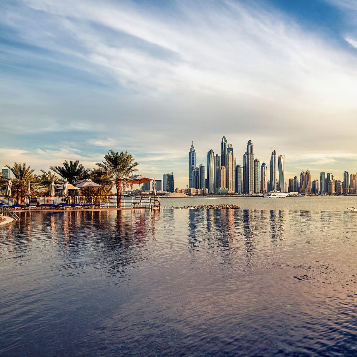 Dubai, United Arab Emirates cityscape with luxury waterfront area and iconic skyscrapers in the background.