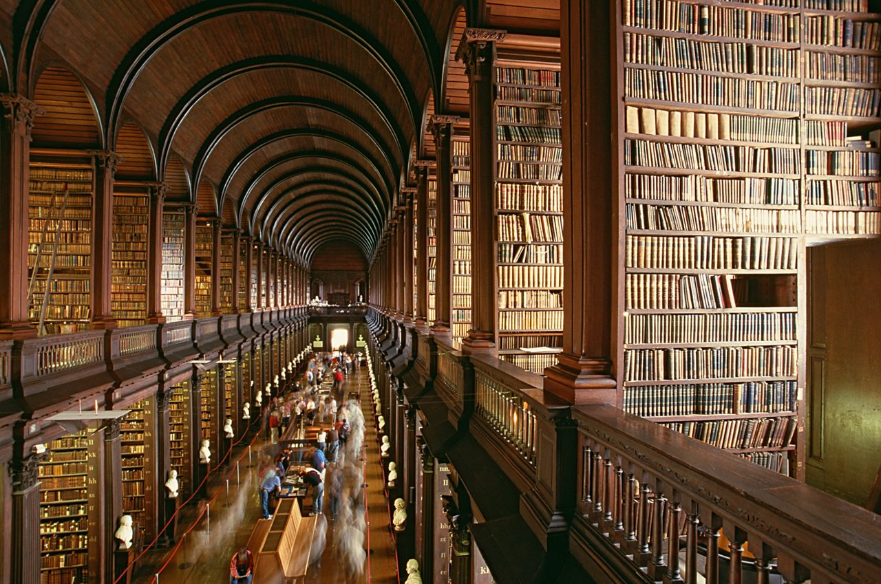 Grand library with high arched ceiling and rows of bookshelves. 