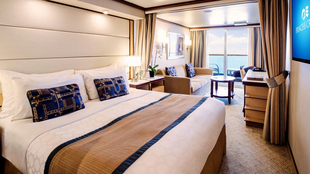A beautifully appointed Princess stateroom offers plush bedding and warm lighting for a hotel-quality experience at sea.