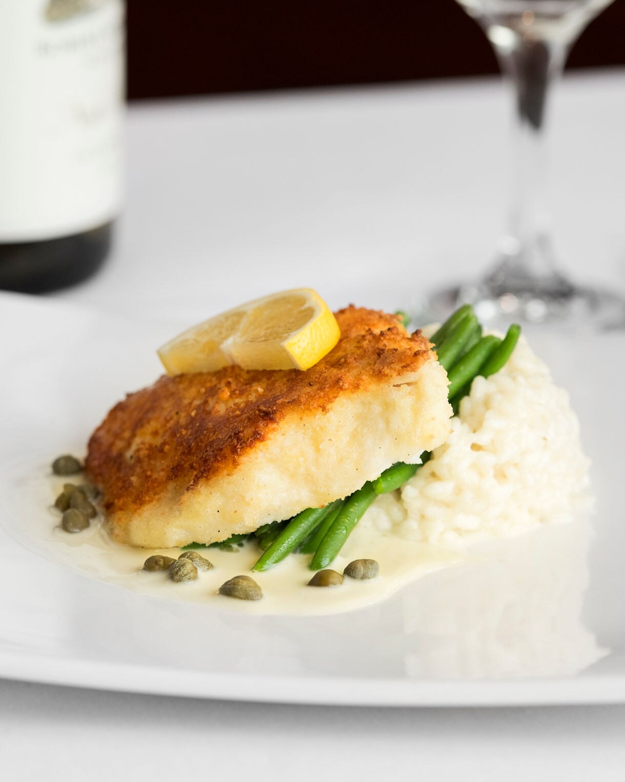 Panko‑ and parmesan‑encrusted Alaskan halibut with coconut curry sauce, served at the Edgewater Restaurant.