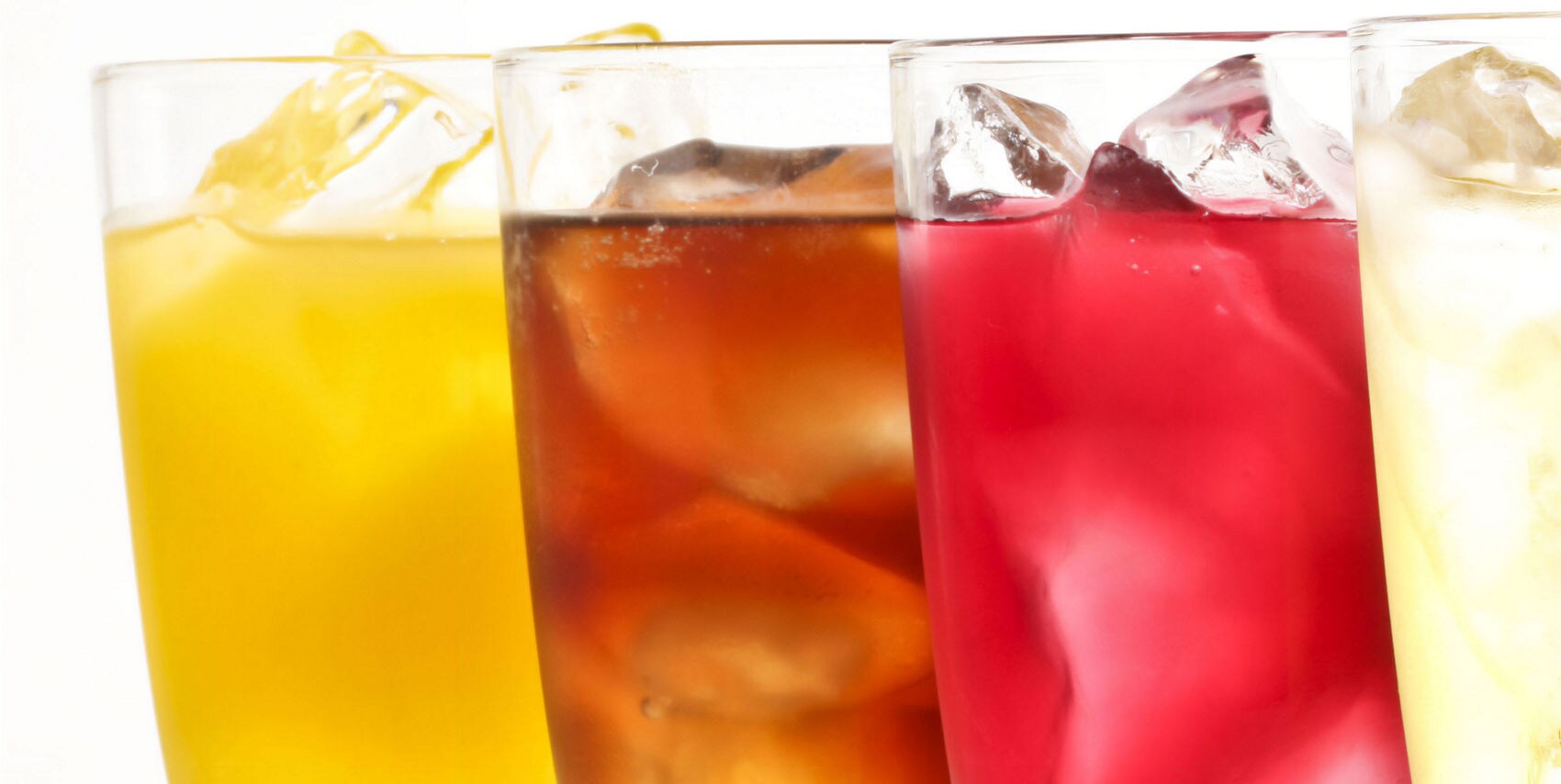 Four colorful cold drinks — yellow, brown, red, and clear — lined up side by side with ice.