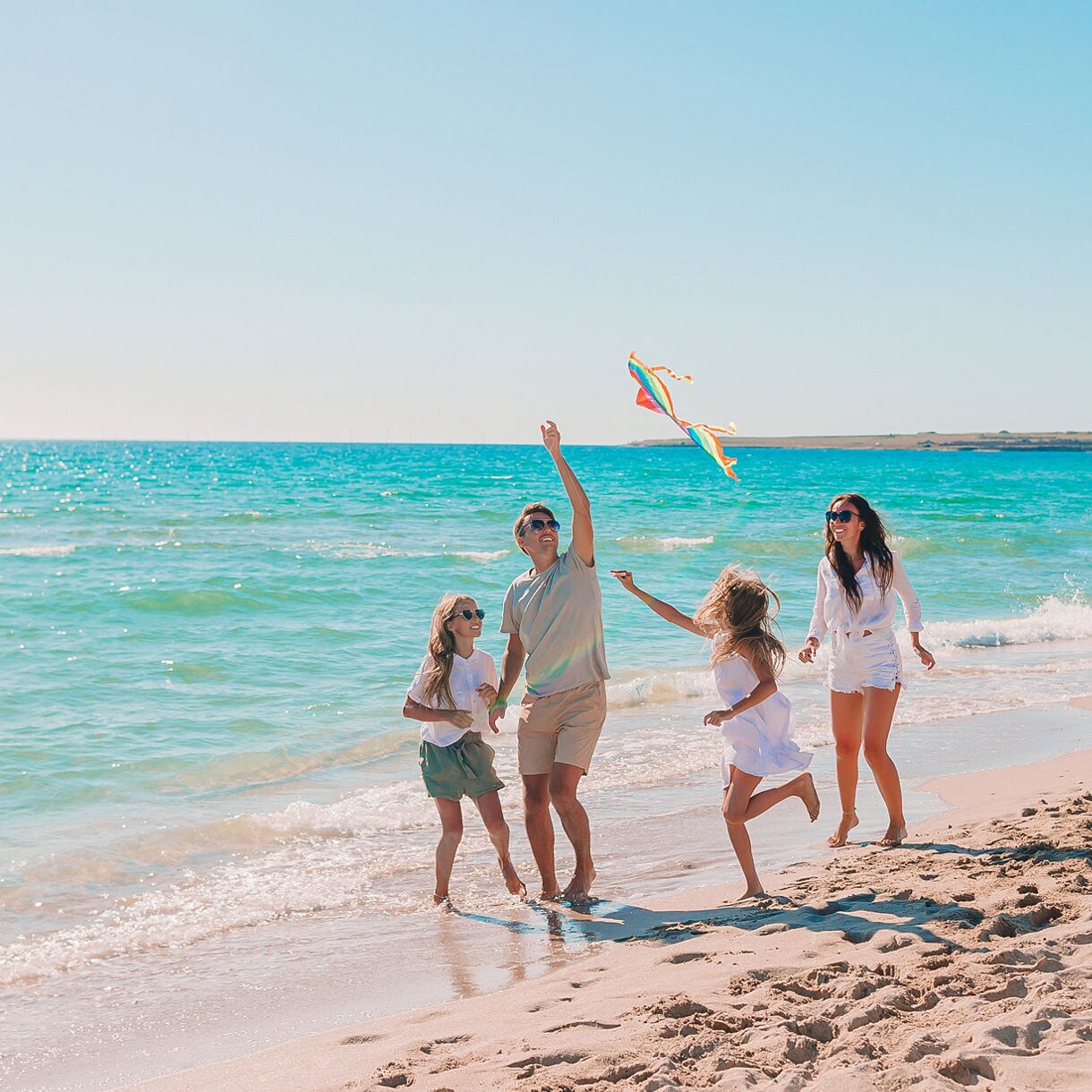 Young family on vacation flying a kite at Fort Lauderdale beach.