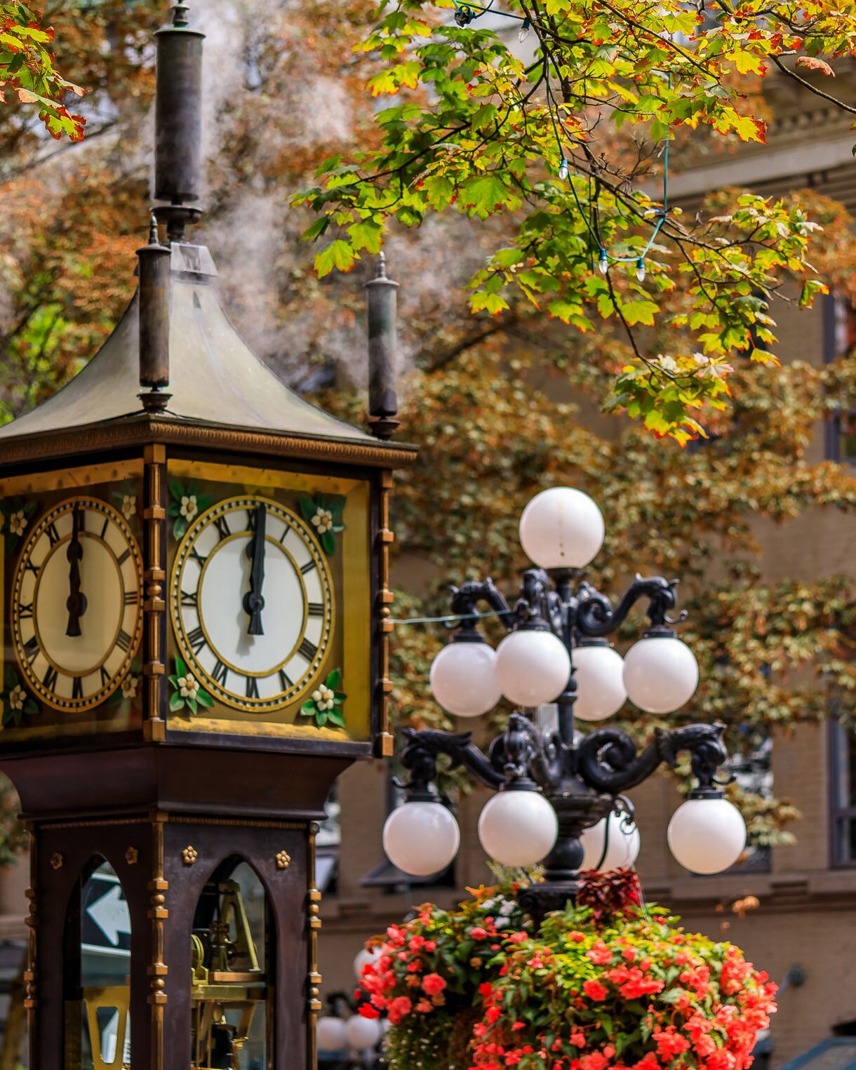 Iconic steam-powered clock in Vancouver’s Gastown with steam rising and autumn leaves in the background.